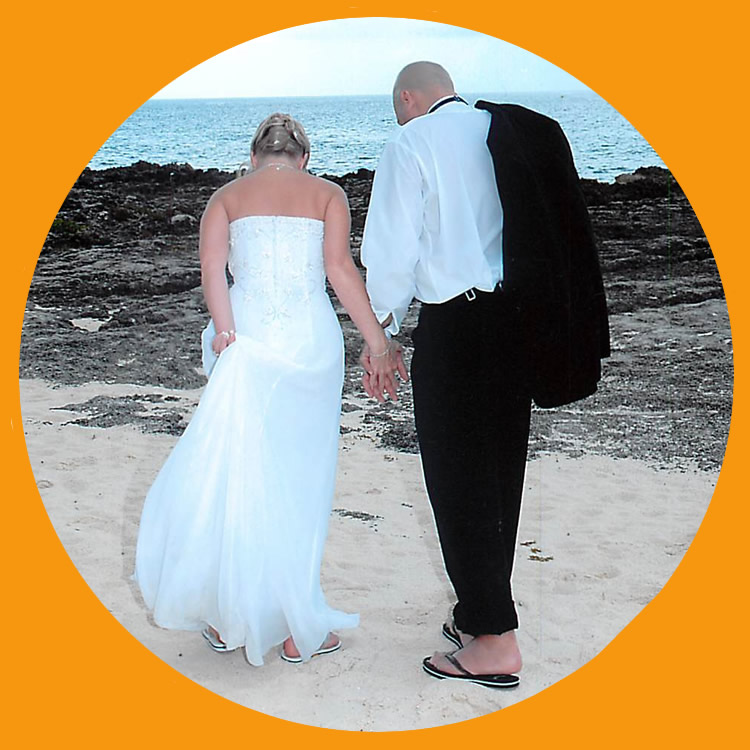 the bride and groom walking in the sand after the nuptials 