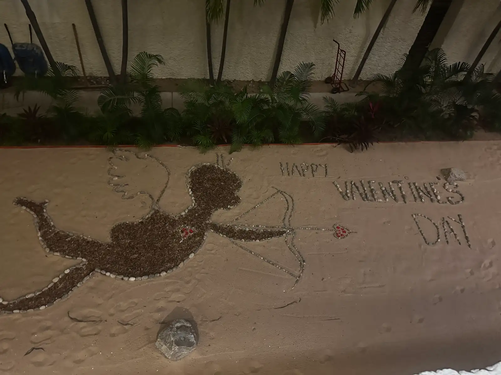 A Valentine's Day message written in the sand, viewed from an upper floor