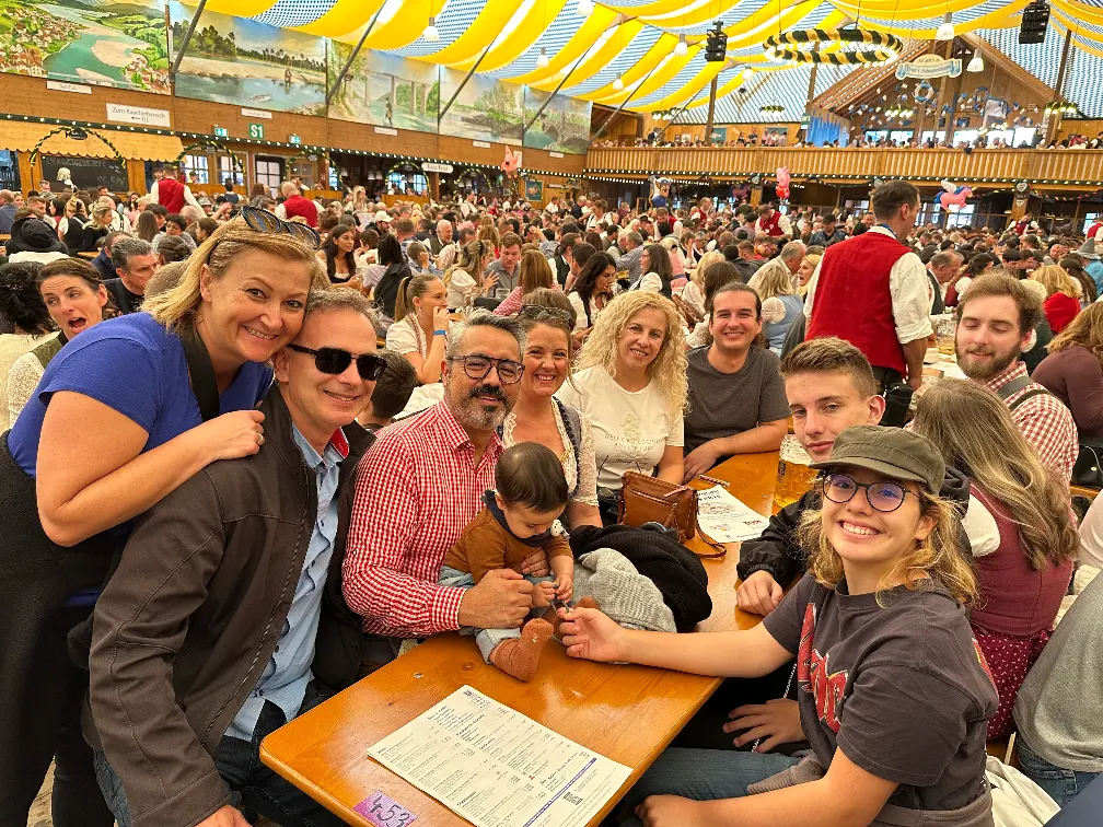An international group of new friends raising beer steins together at Oktoberfest