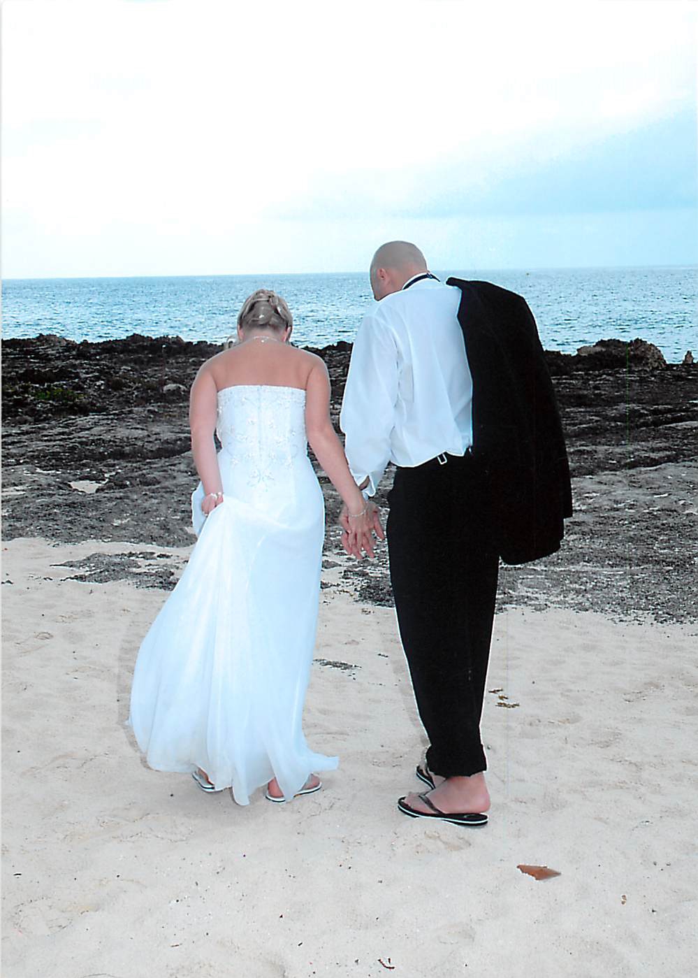 Couple walking along the beach after their destination wedding ceremony